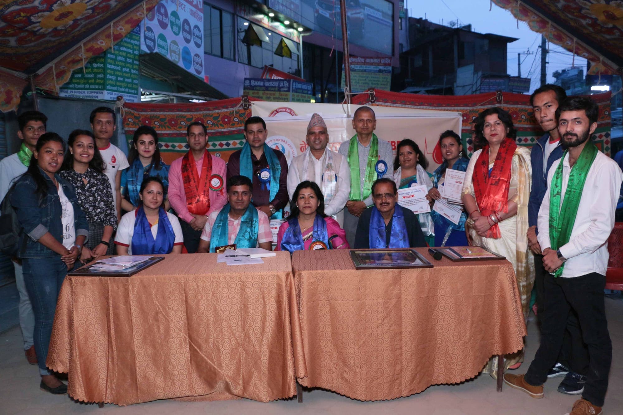 INBDA volunteers and guests standing behind the registration table at a blood donation camp